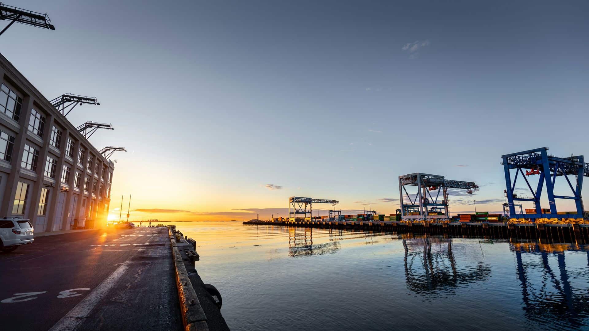 Terminal de contenedores al atardecer con grúas portuarias