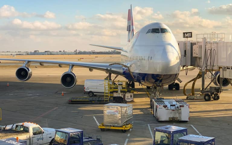 Avión de carga en la terminal con mercancía a pie de pista